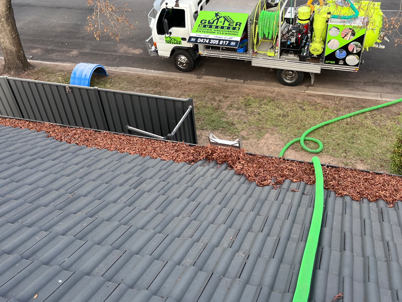 John from Gutter Muncher using professional gutter vacuuming equipment on a roof